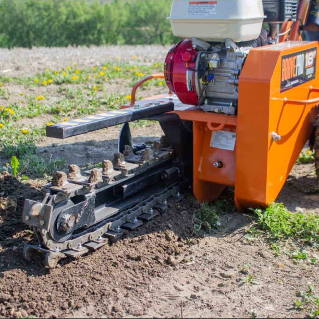 Orange brave pro 18 trencher on a field with grass and small flowers.