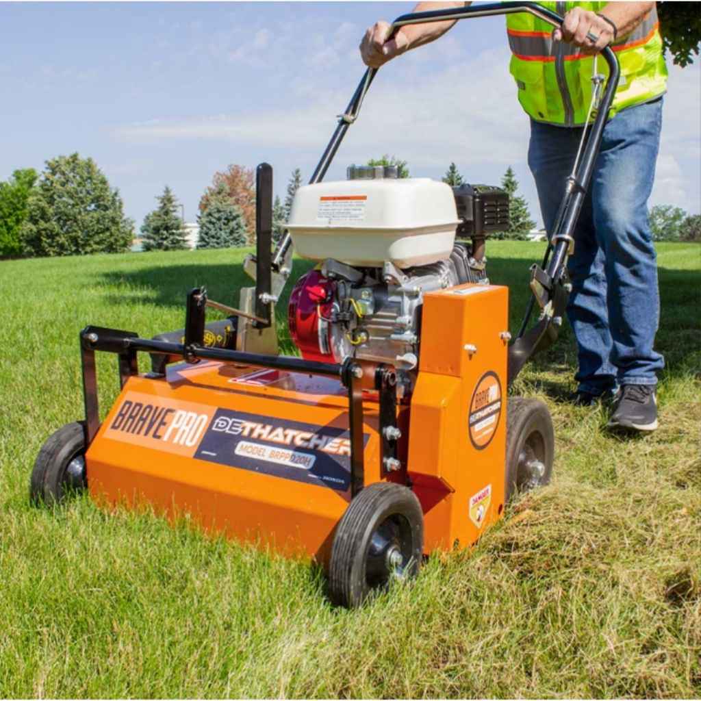 Person using a Brave dethatcher on grass
