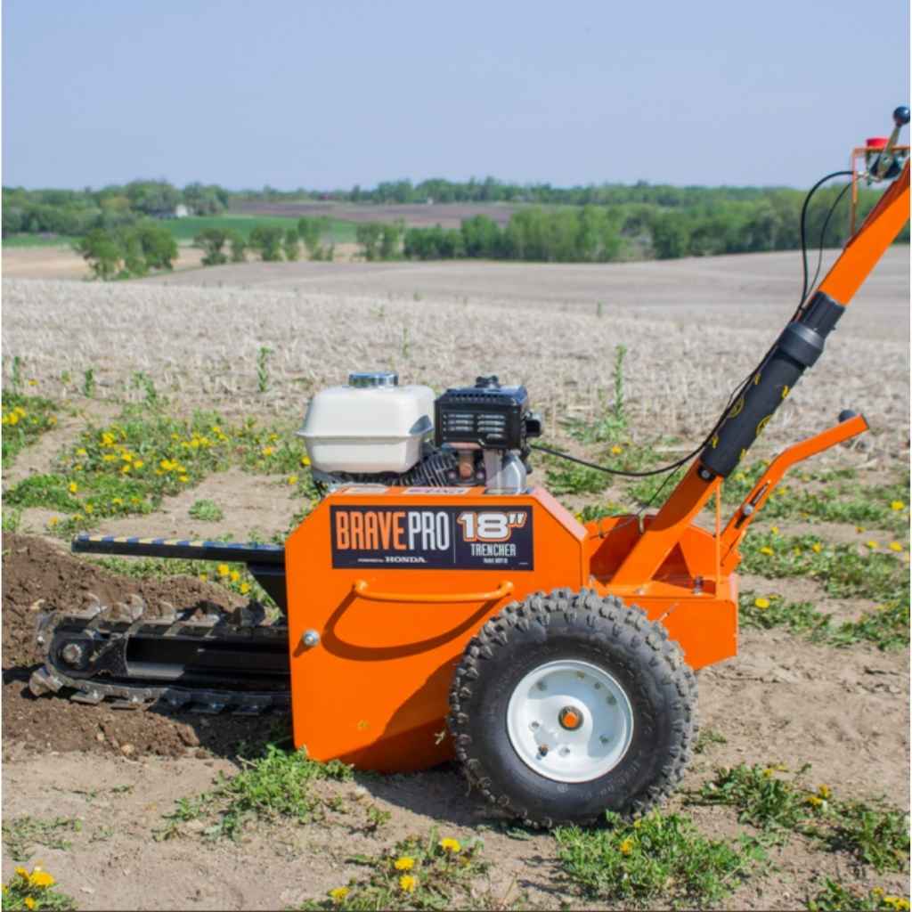Orange BravePro 18 inch trencher in a field with a clear sky