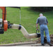 Person using a bravepro chipper shredder vacuum truck loader briggs & stratton 18 hp engine 10in model brptl160b with a long hose in a grassy area.