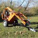 Orange Brave Towable Auger on a grassy area with trees in the background
