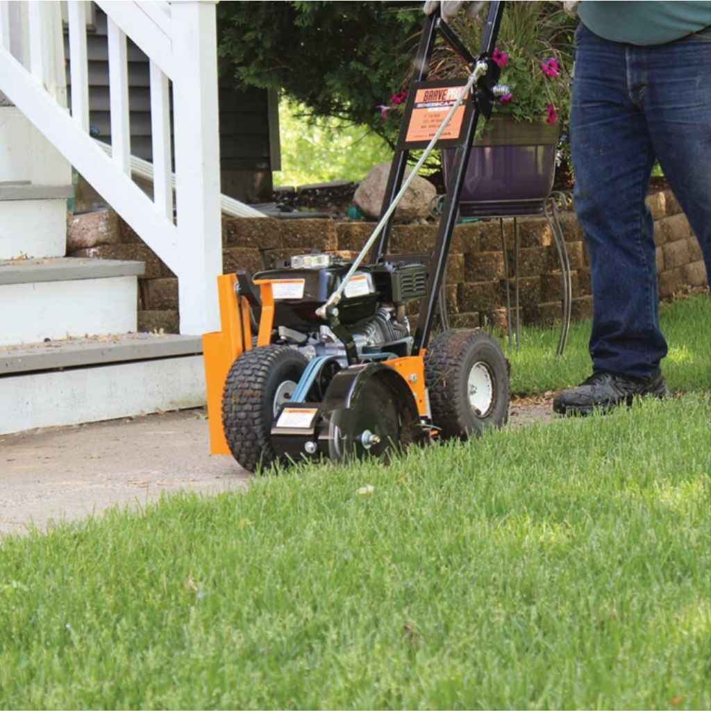 Person using a Brave star blade lawn edger on a grassy area with a house in the background