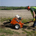 person using an orange brave pro 18 in. trencher on a field