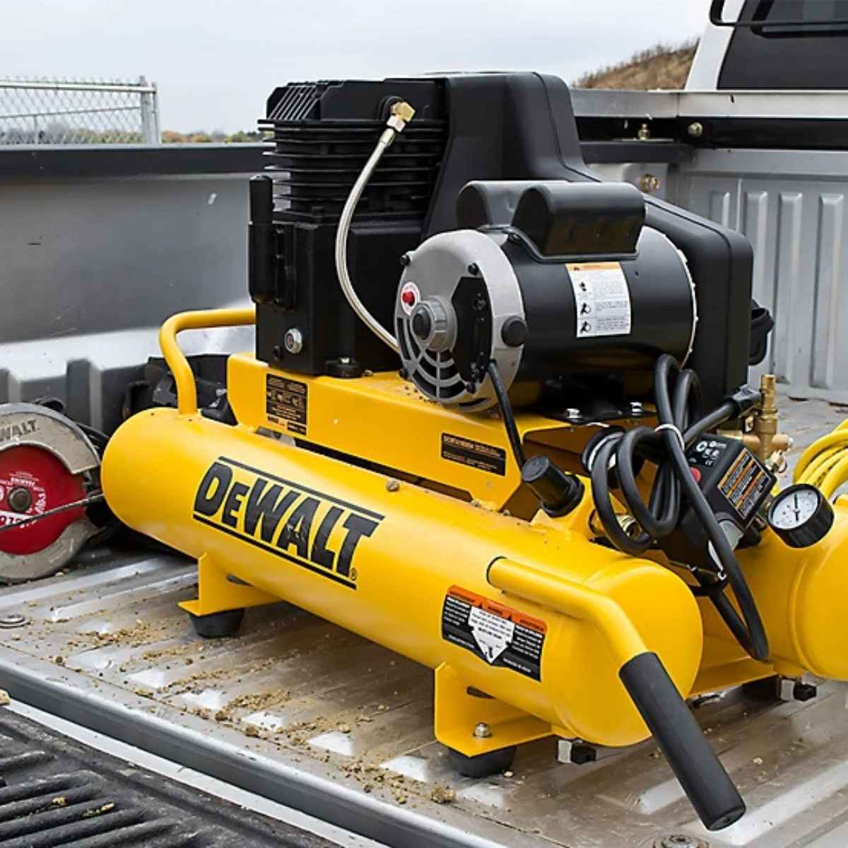 Yellow Dewalt 8 gal 1.9hp wheelbarrow air compressor on a truck bed