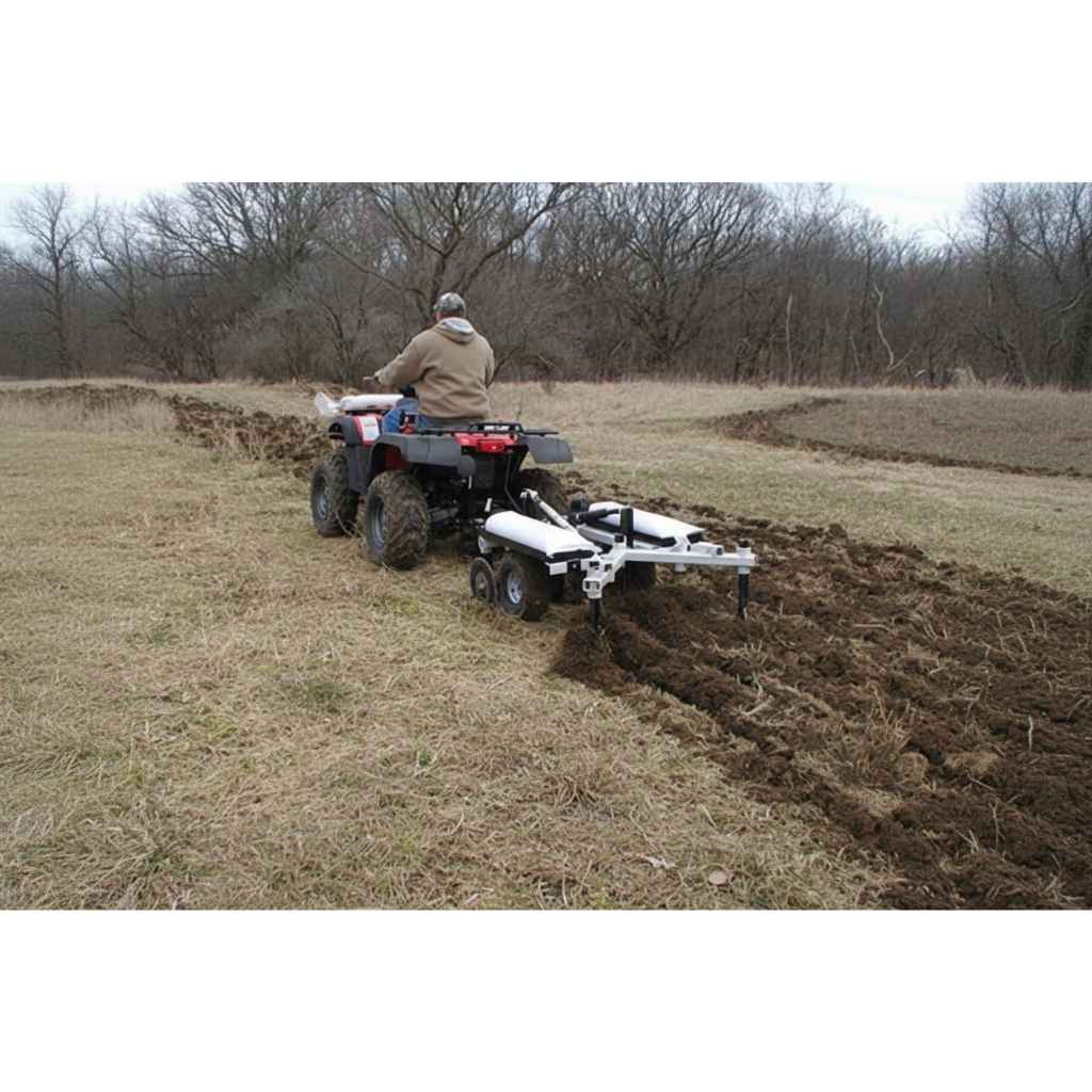 Person operating an ATV with a GreyWolf Till N Claw Chisel Plow & Cultivator 43 Inch in a field