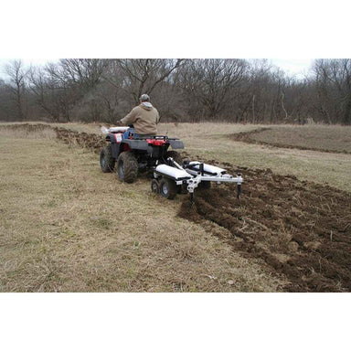 Person operating an ATV with a GreyWolf Till N Claw Chisel Plow & Cultivator 43 Inch in a field
