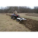 Person operating an ATV with a GreyWolf Till N Claw Chisel Plow & Cultivator 43 Inch in a field