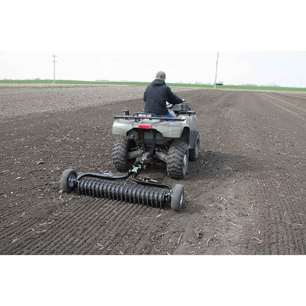 Person operating an ATV with a Greywolf till n claw cultipacker on a field