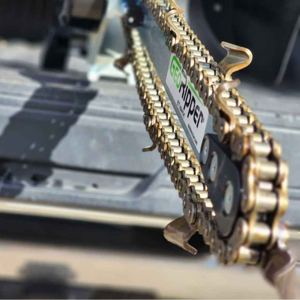 a close up of the chain for a minitrencher georipper sitting in the bed of a truck
