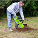 person operating a georipper trencher for sale in a grassy yard with trees in the background during the day.