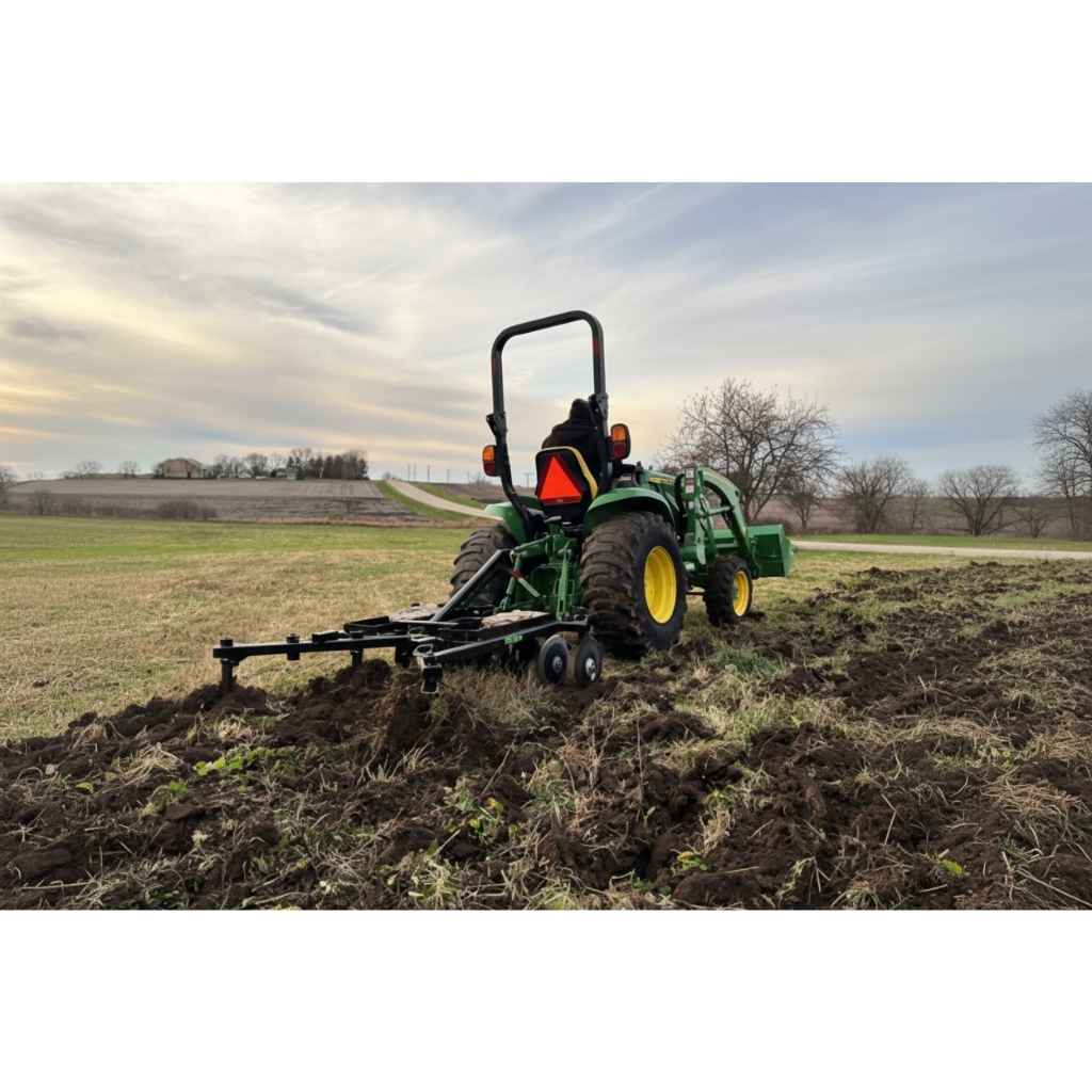 Tractor plowing a field with a greywolf 3 point till n claw with a cloudy sky in the background