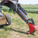 red and grey greywolf skid steer backhoe in a field.