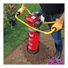 Person using Model one RD2 auger with red blade and yellow handles to create a hole in the ground.