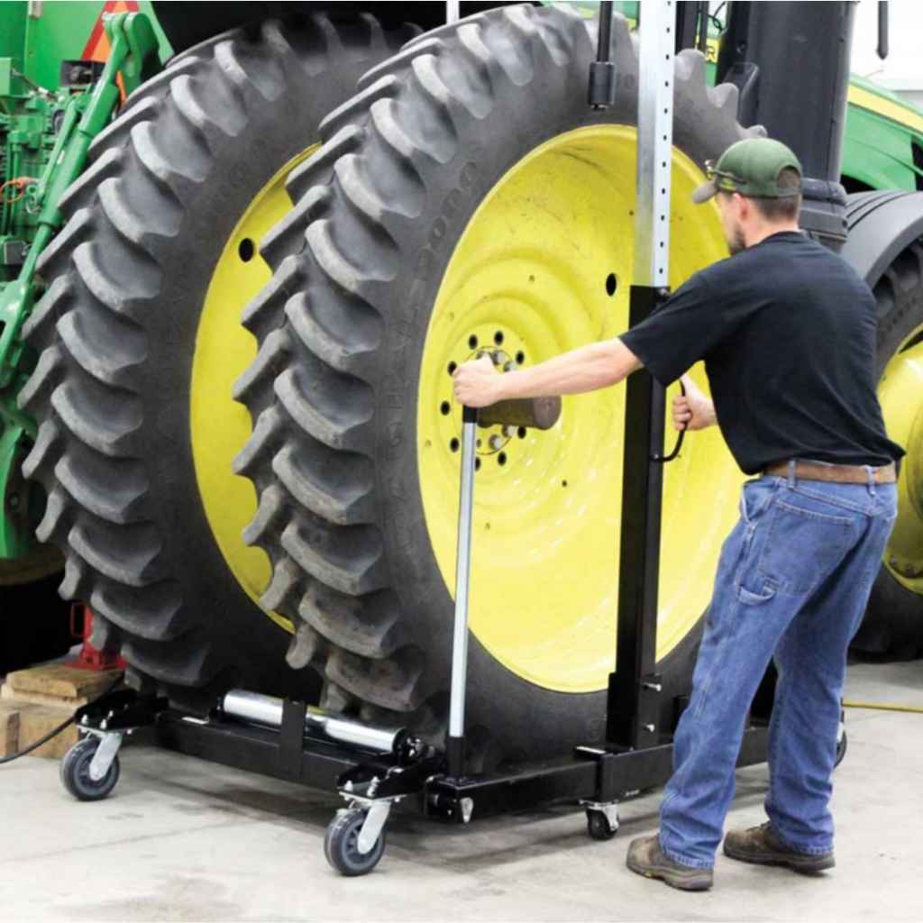 Person using a k & M manufacturing wheel dolly on a large tractor tire