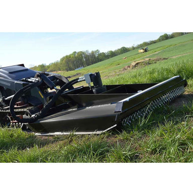 A Loflin Fabrication Mini Skid Steer Brush Cutter on a grassy field with trees in the background.