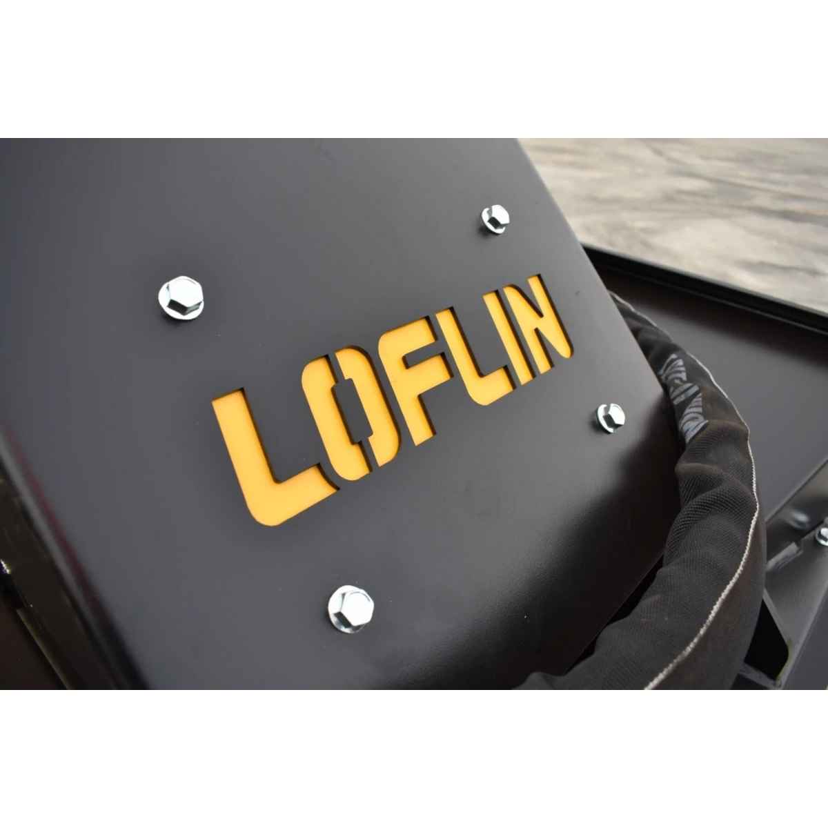 Close-up of a black Loflin mini excavator brush cutter with the word LOFLIN in bold yellow letters and several silver bolts, photographed against a light gray background.