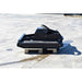 A black loflin mini skid steer brush cutter, resting on a wooden pallet on a light gray concrete surface.