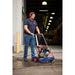 Man operating a Makinex 2200 PSi Dual pressure cleaner in a factory setting on an asphalt floor.