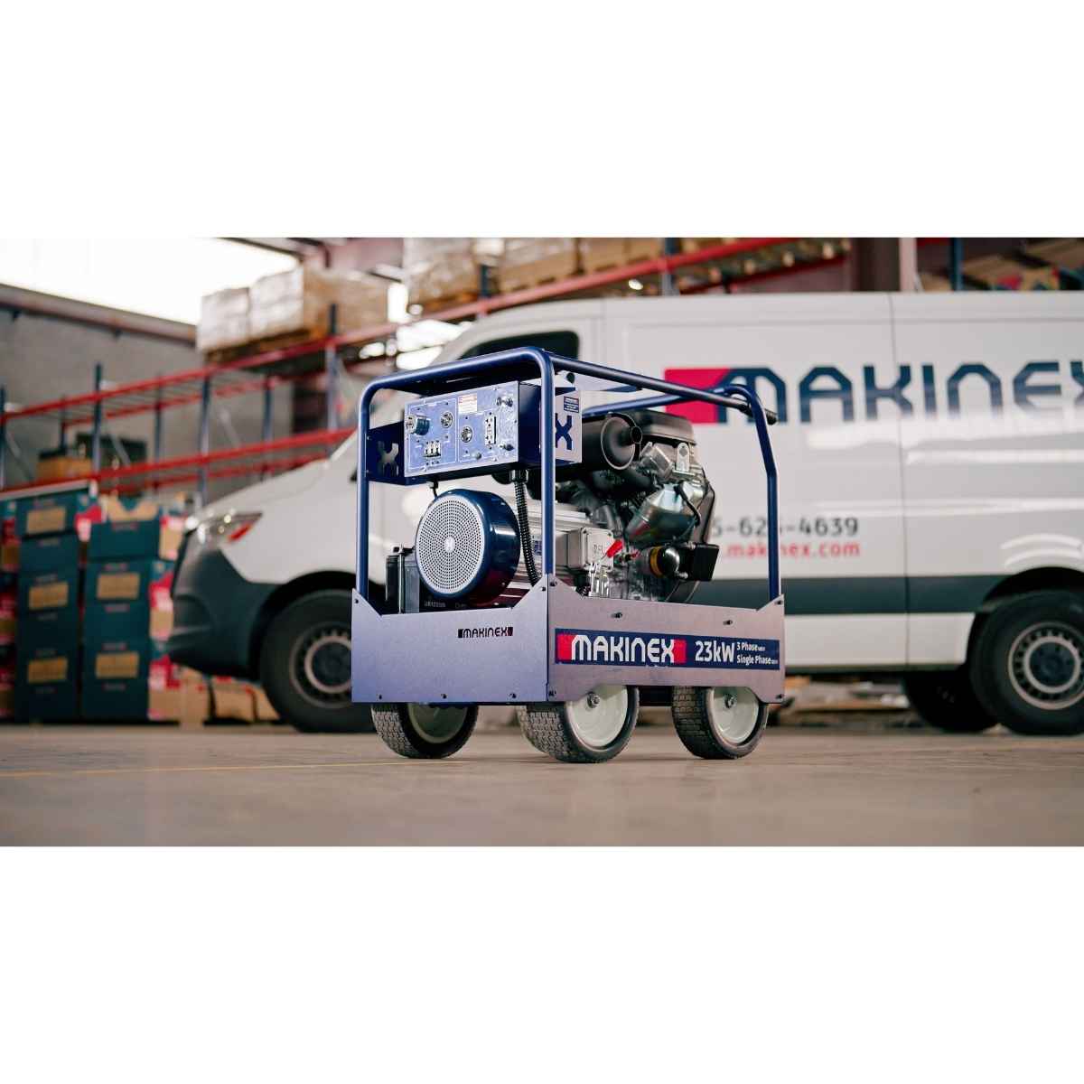 A Makinex 23W Generator on a wheeled cart, positioned in a warehouse setting with a white Makinex van in the background.