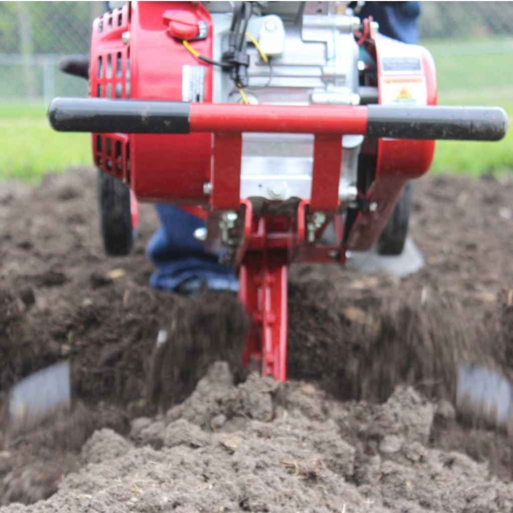 Red Maxim RMT55H Commercial tiller being used in a field