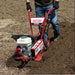 Person using a Maxim compact rm4h tiller on a dirt field