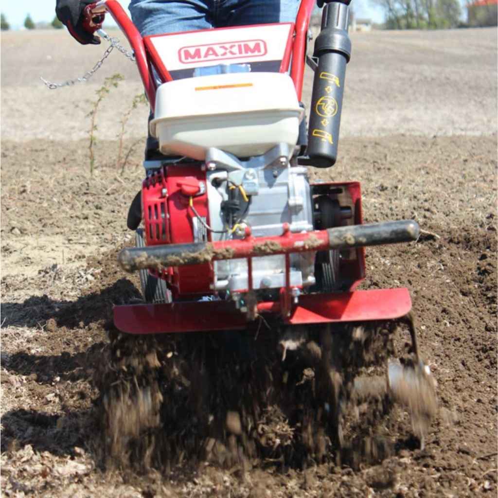 Person operating a Maxim compact tiller in a field