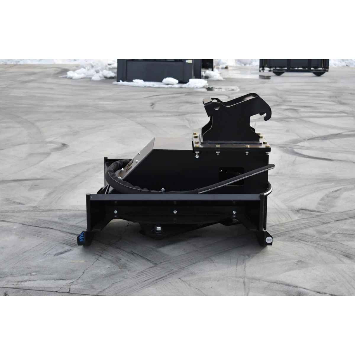 A heavy-duty black loflin Brush cutter for mini excavator resting on a gray paved surface outdoors.