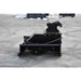 A heavy-duty black loflin Brush cutter for mini excavator resting on a gray paved surface outdoors.