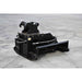A heavy-duty black loflin fabrication mini excavator brush cutter attachment, photographed on a gray concrete surface.