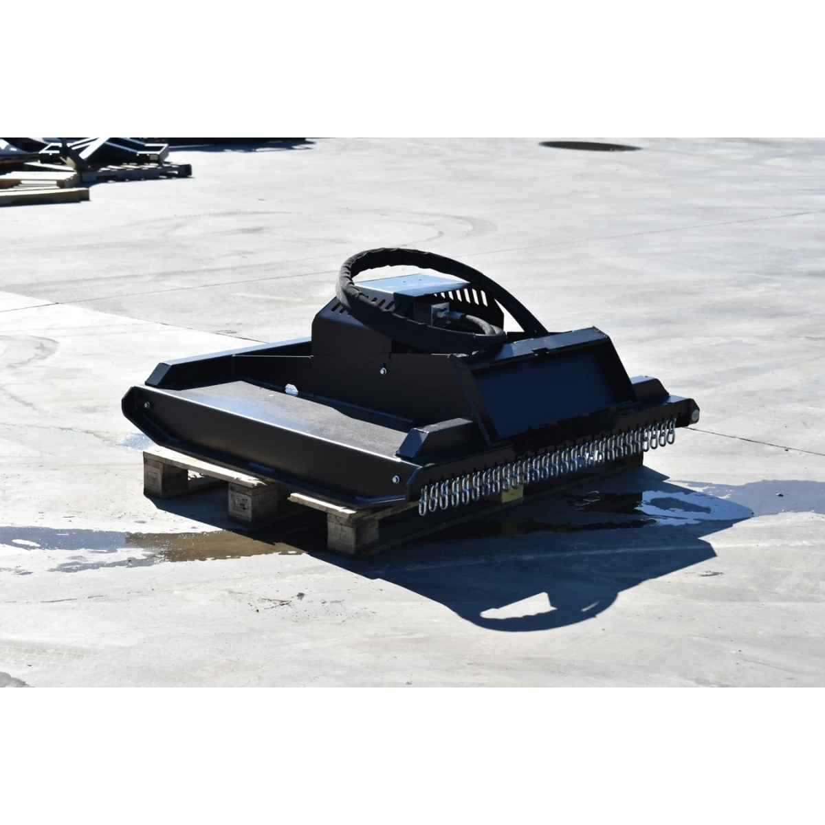 A black mini skid steer brush cutter by loflin resting on a wooden pallet on a concrete surface.