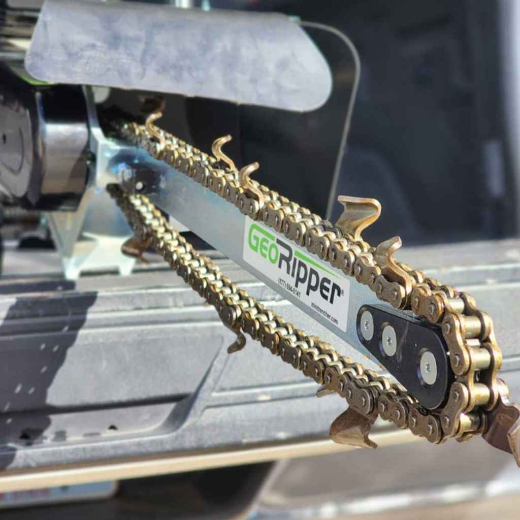 Close up of the chain of a georipper mini trencher sitting in the bed of a truck