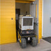 movex tracked cross country carrier xc 30  holding a generator exiting a storage unit door.