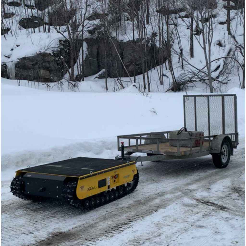 Yellow movex tracked xc 48 towing a trailer on a snowy path