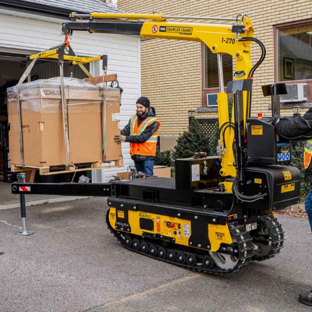 Movex mini crawler crane xc 270 lifting a load with a person in an orange vest nearby.