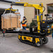 Movex mini crawler crane xc 270 lifting a load with a person in an orange vest nearby.