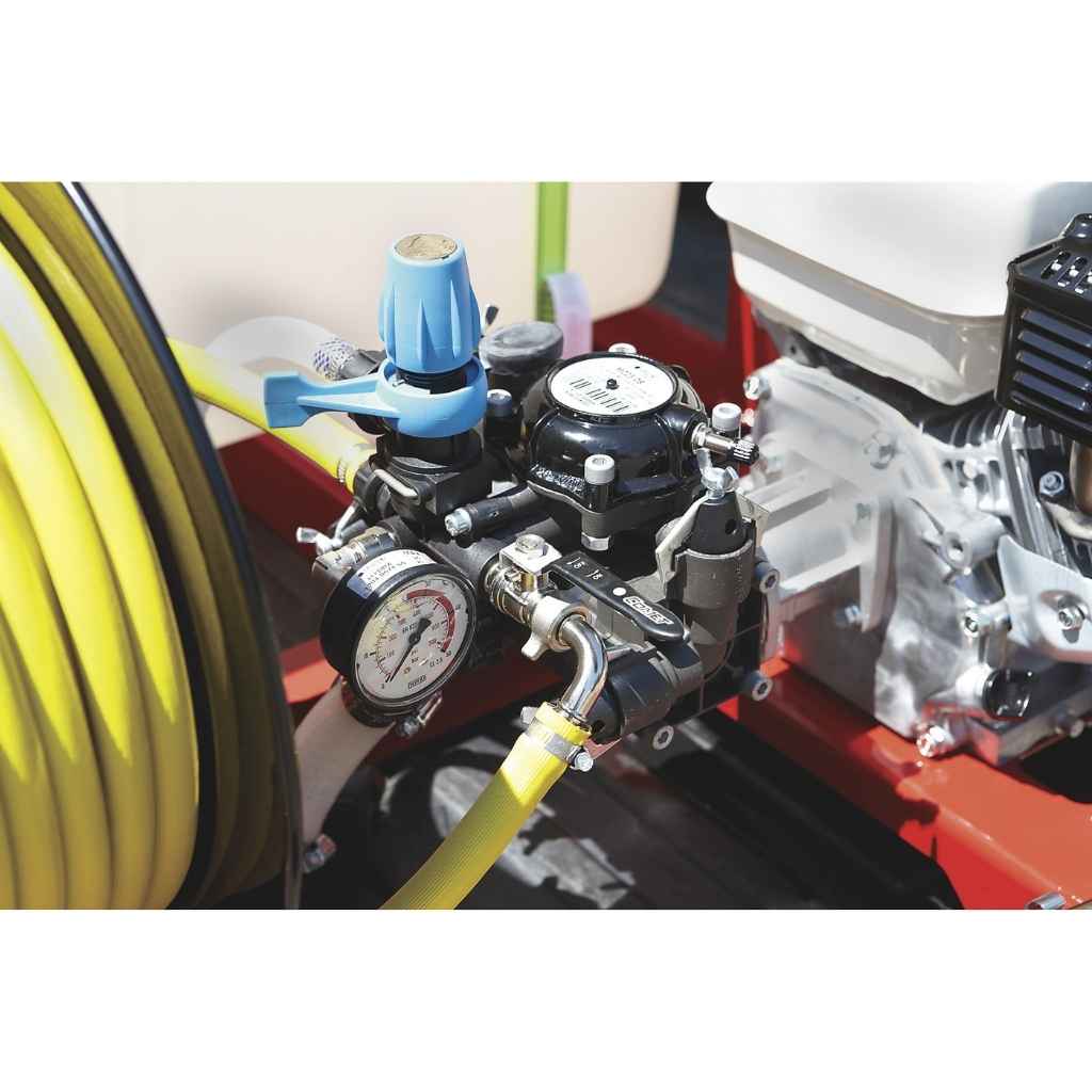 Close-up of a mechanical pressure regulator on a north star skid sprayer 100 gallon capacity with hoses and a gauge on a white background