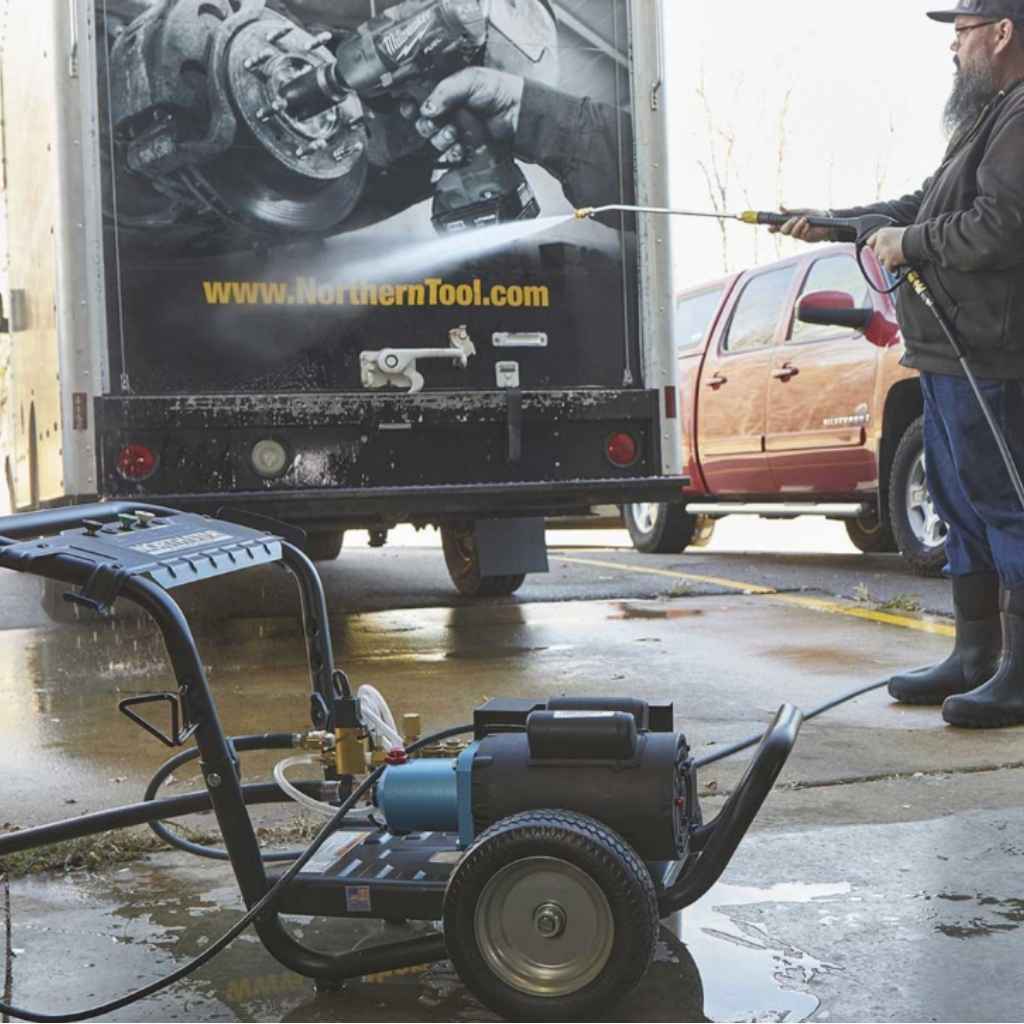 Person using a northstar 120v electric pressure washer in front of a truck with Northern Tool advertisement.