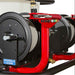 Close-up of a northstar trailer mounted 4000 psi pressure washer Coxreels reel with red housing and black reels on a white background