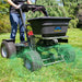Person using a spyker 120 lbs ride on  spreader to broadcast grass seed on a lawn