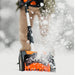 Person using a SuperHandy orange and black snow shovel to clear snow