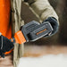 person puting a battery into a Superhandy snow thrower pro 48 v in a snowy setting