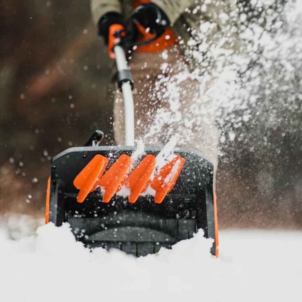 Person using a superhandy 48 v snow blower to clear snow