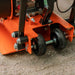 Close-up of an orange superhandy 7 hp plate compactor with water tank with wheels on a concrete surface