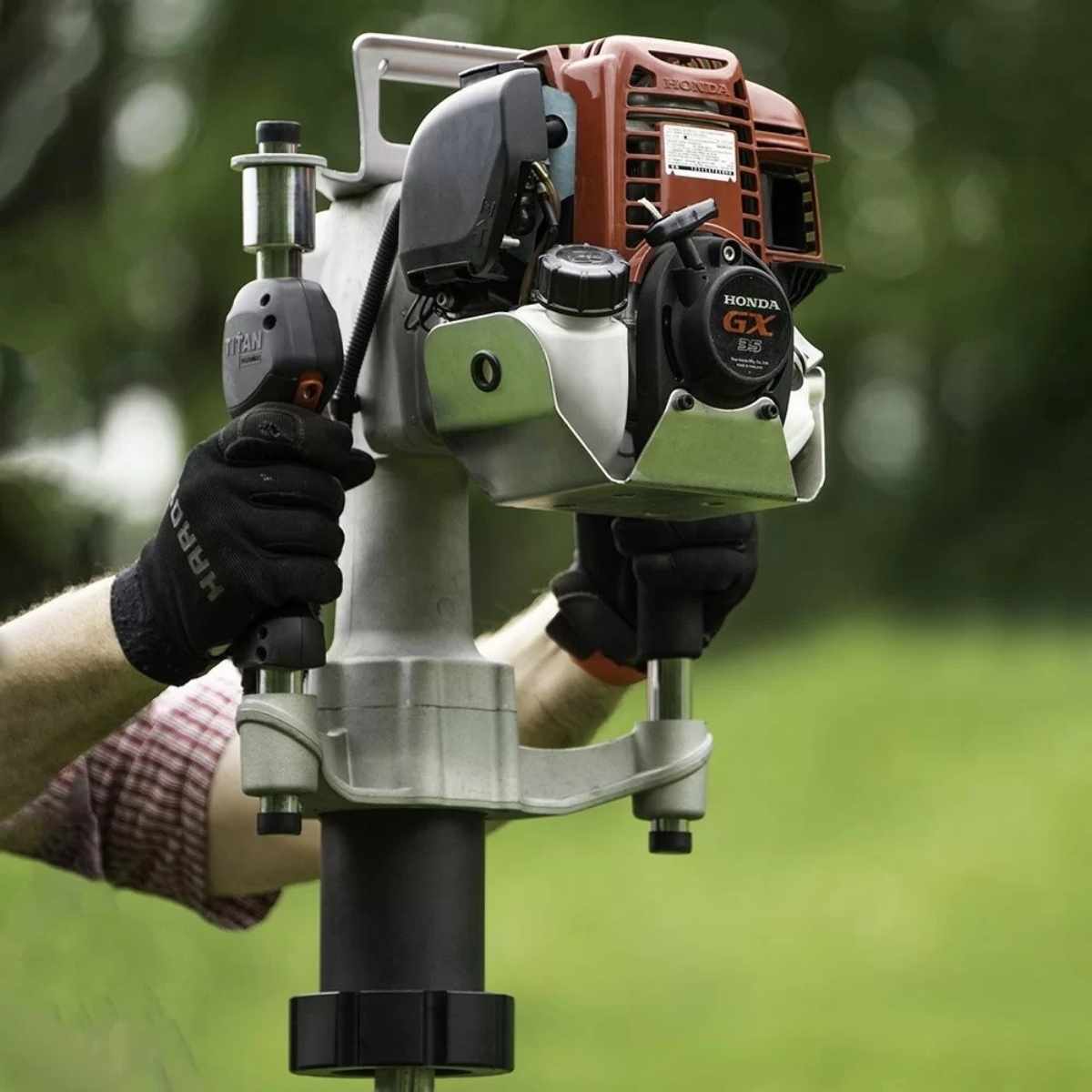 Person holding a Titan pgd3200x post driver with a blurred green background