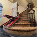 Zonzini Domino Plasmoid Stabilized stair climber carrying a radiator up a curved staircase in a home setting