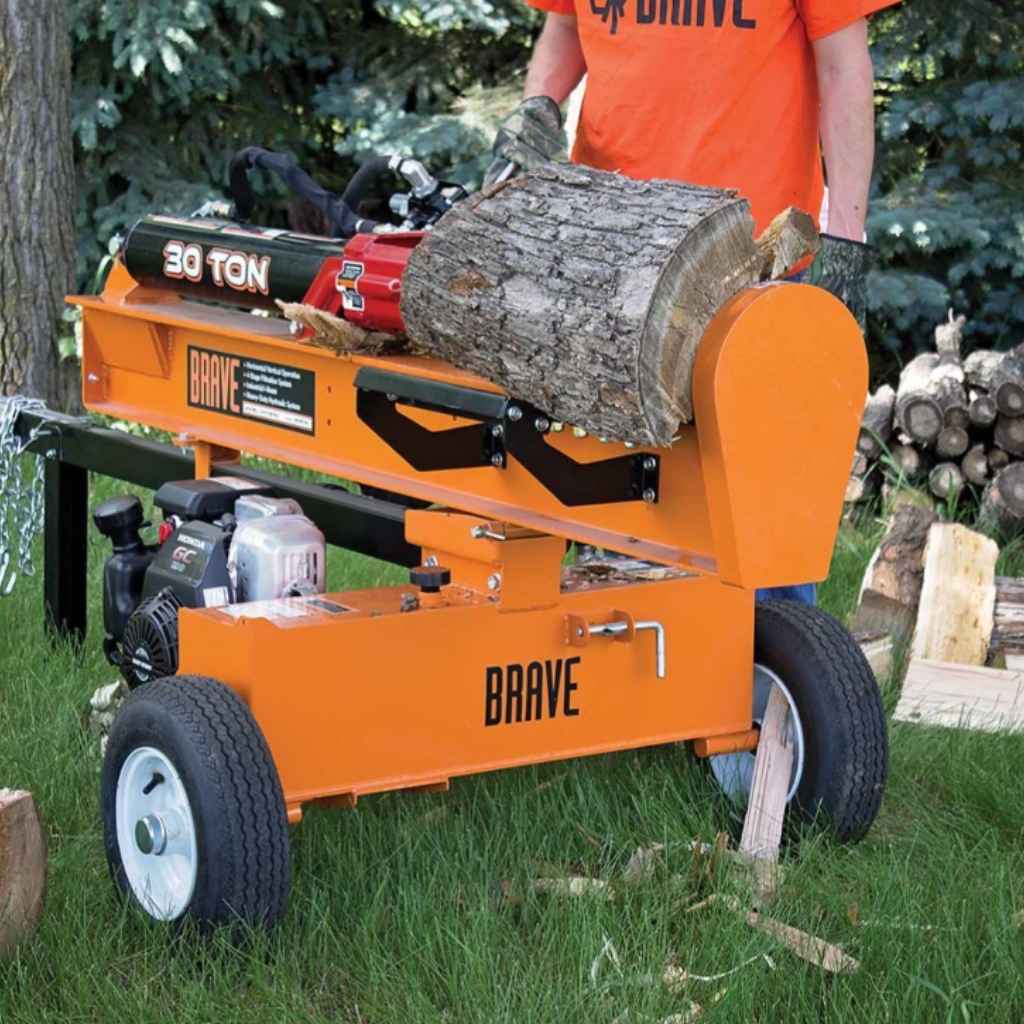 Orange brave towable 30 ton log splitter with a person loading a log, set against a natural outdoor background.