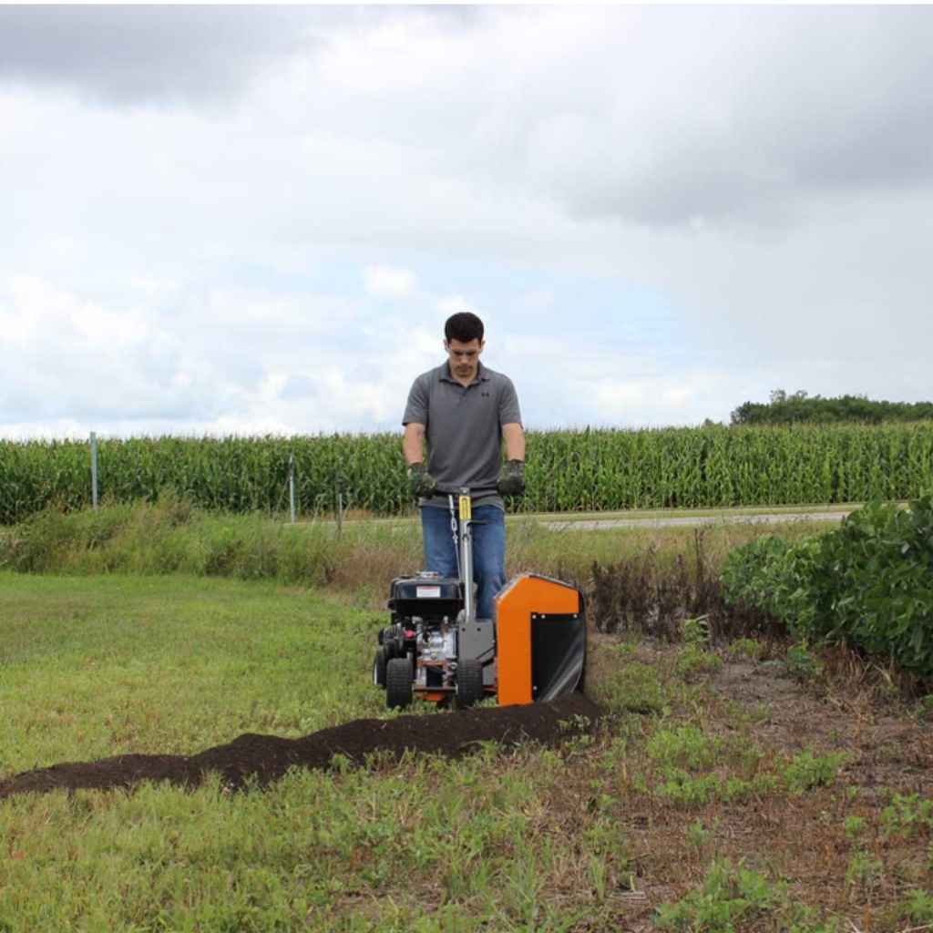 Person operating a bravepro bed sculptor bed edger in a field with cornfields in the background