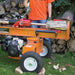 Person operating a brave pro towable 24 ton log splitter with logs around