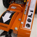 Close-up of an orange brave 14 hp stump grinder with warning labels on a white background