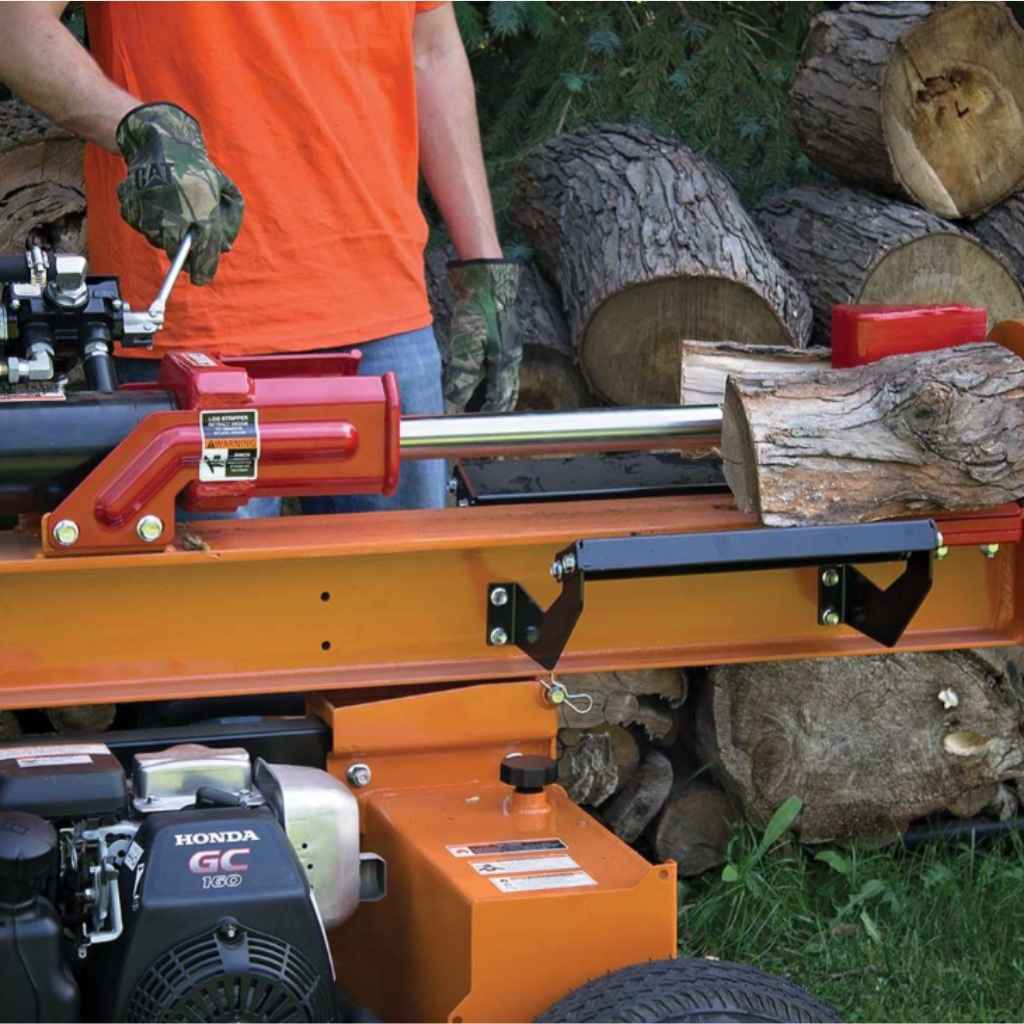 Person operating a brave 24 ton towable log splitter with logs around
